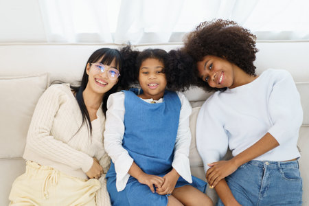 Concept of diversity in ethnic people spending a time together in a weekend. A diverse group and generation people relaxing and playing a video game together in living room.の写真素材