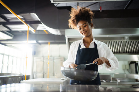Happy African - black professional chef cooking in kitchen in restaurant.の写真素材