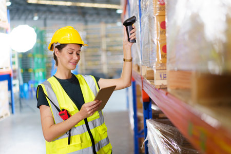 Happy cheerful caucasian white female warehouse worker using laser barcode reader to scan stock inventory in warehouse. Professional occupation in logistic industrial concept.の写真素材