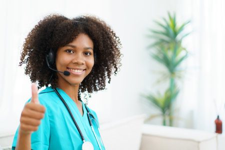 American - African black ethnicity female doctor gives a consultation to patient, online or tele medicine service. Doctor talking to patient through online video conference.の写真素材