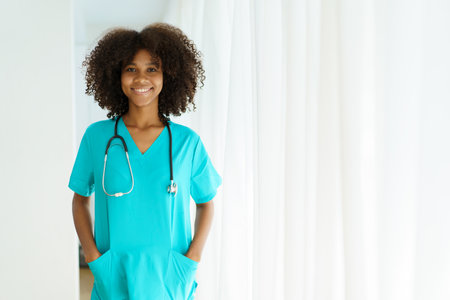 Beautiful American - African black ethnicity female doctor standing in the hospital portrait with copyspace. Surgery female doctor portrait at hospital.の写真素材