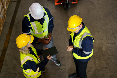 Diversity ethnicity of warehouse staff or engineer making a discussion together before start working, team of engineer in factory making a morning brief before working.の写真素材