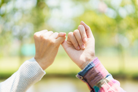 Asian women touching their fingers together. Concept of trust and friendship.の写真素材