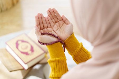 Beautiful Asian young Muslim woman sit on the floor in her house and praying for a holy god - Allah in Islam believe.の写真素材