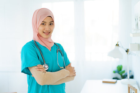 Asian female muslim doctor showing a doctor stethoscope to camera close up with copyspace. An expertise or occupation in modern muslim people concept.の写真素材