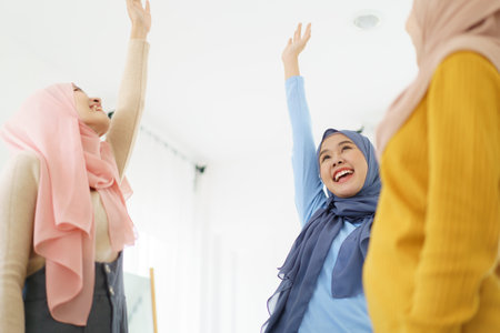 Group of a beautiful smart Asian muslim woman standing in the room and having a discussion together. Modern muslim society concept, women muslim student talking.の写真素材