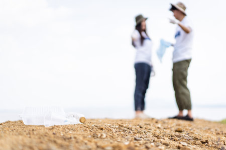 Group of Asian young people volunteer helping to collecting or picking up a plastic bottle garbage...