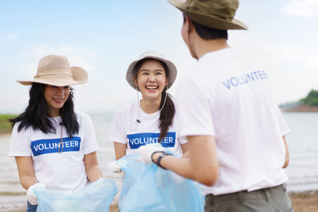 Group of Asian young people volunteer helping to collecting or picking up a plastic bottle garbage on the ground in park. Sustainability and environment conservation concept.の写真素材