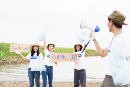 Group of Asian young people volunteer helping to collecting or picking up a plastic bottle garbage on the ground in park. Sustainability and environment conservation concept.の写真素材