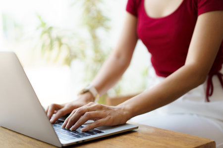 Beautiful Asian young woman working in co-working space in coffee shop by using laptop computer and smartphone. Concept of modern working lifestyle and work life balance.の写真素材