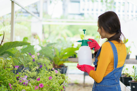 Happy Asian woman and little boy planting a house plants in green house together. Satisfied little boy enjoy planting a small tree with mother.の写真素材