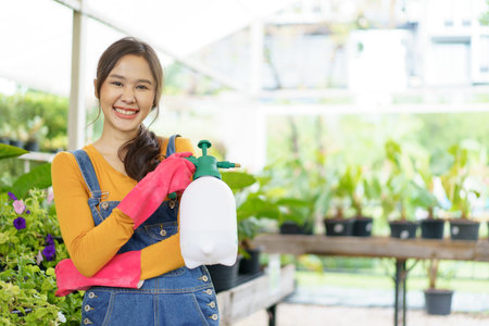 Happy Asian woman and little boy planting a house plants in green house together. Satisfied little boy enjoy planting a small tree with mother.の写真素材