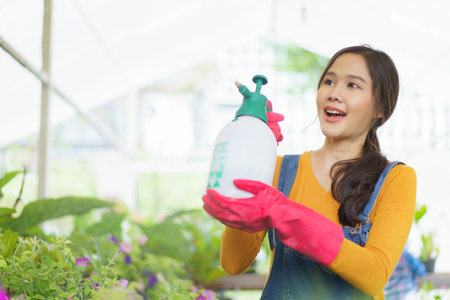 Happy Asian woman and little boy planting a house plants in green house together. Satisfied little boy enjoy planting a small tree with mother.の写真素材
