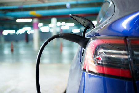 Electric Vehicle or EV car is charging at the public AC - charging station. AC type 2 charging connector plug now connected on the modern EV car at charging station.の写真素材