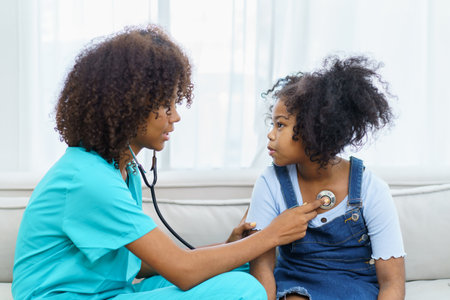 African American ethnicity female doctor and little girl in hospital, pediatrician taking to a little girl who laying down on the bed or sofa in hospital to talk about her sickness.の写真素材