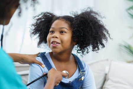 African American ethnicity female doctor and little girl in hospital, pediatrician taking to a little girl who laying down on the bed or sofa in hospital to talk about her sickness.の写真素材