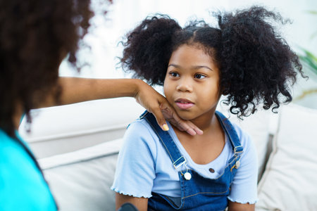 African American ethnicity female doctor and little girl in hospital, pediatrician taking to a little girl who laying down on the bed or sofa in hospital to talk about her sickness.の写真素材