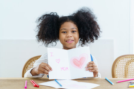 Happy cheerful little American - African ethnicity girl enjoy practice drawing and painting on paper, little girl learning art and creativity skill.の写真素材