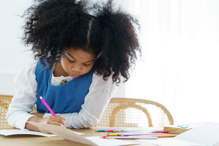 Happy cheerful little American - African ethnicity girl enjoy practice drawing and painting on paper, little girl learning art and creativity skill.の写真素材