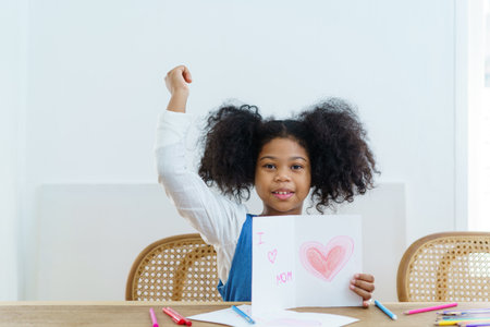 Happy cheerful little American - African ethnicity girl enjoy practice drawing and painting on paper, little girl learning art and creativity skill.の写真素材