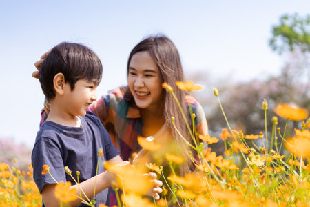 Happy Asian woman and son relaxing in the meadow field.の写真素材