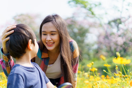 Happy Asian woman and son relaxing in the meadow field.の写真素材