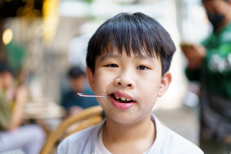 Funny face of Asian little boy enjoy eating an ice cream.の写真素材