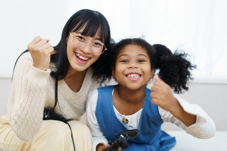 Concept of diversity in ethnic people spending a time together in a weekend. A diverse group and generation people relaxing and playing a video game together in living room.の写真素材