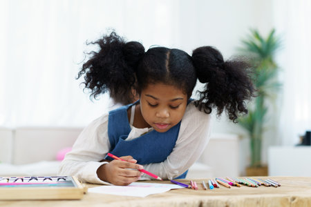 Happy cheerful little American - African ethnicity girl enjoy practice drawing and painting on paper, little girl learning art and creativity skill.の写真素材