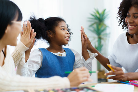 Happy cheerful American - African ethnicity little girl enjoy practice drawing and painting together with her sisters. Diversity in family and people concept.の写真素材