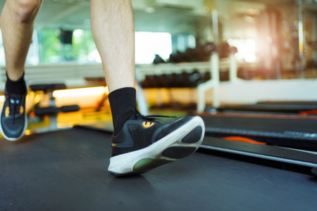 Active Asian sportsman making a cardio exercise by running on the treadmill machine in a fitness or gym, healthy sport man doing a cardio workout.の写真素材