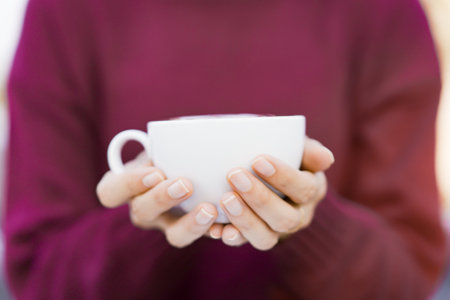 Beautiful Asian young woman holding a coffee cup on a hands close up. Woman enjoy drinking a coffee...