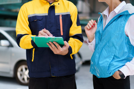 Young caucasian white woman taking technician in garage about vehicla annual check up - maintenance.の写真素材