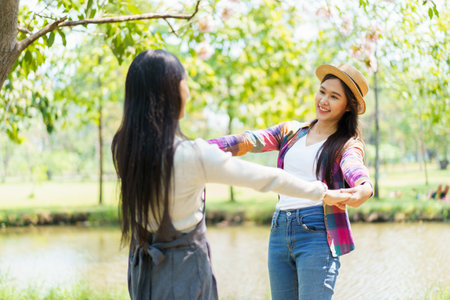 Happy cheerful Asian lovely female couple or LGBT couple hugging together and smiling to camera. Concept of diverse in genders and ethnicity.の写真素材