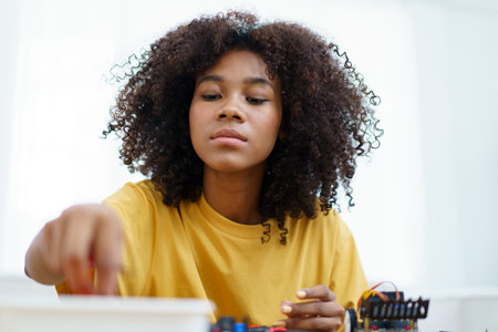 Happy cheerful American - African black ethnicity female university student learning about robotic...