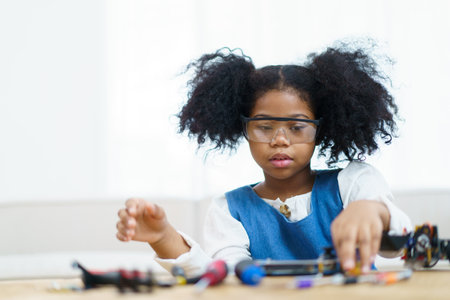 Happy cheerful American - African black ethnicity female university student learning about robotic and programing by herself, woman assemble a robot.の写真素材