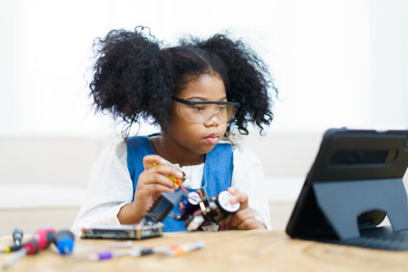 Happy cheerful American - African black ethnicity female university student learning about robotic and programing by herself, woman assemble a robot.の写真素材