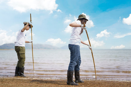 Group of Asian young people volunteer helping to collecting or picking up a plastic bottle garbage...