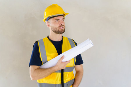 Portrait of smart and good looking caucasian white male foreman or construction contractor smiles to camera and looks away. Close up shot of construction engineer - foreman with copyspace.の写真素材