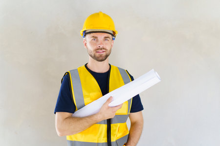 Portrait of smart and good looking caucasian white male foreman or construction contractor smiles to camera and looks away. Close up shot of construction engineer - foreman with copyspace.の写真素材