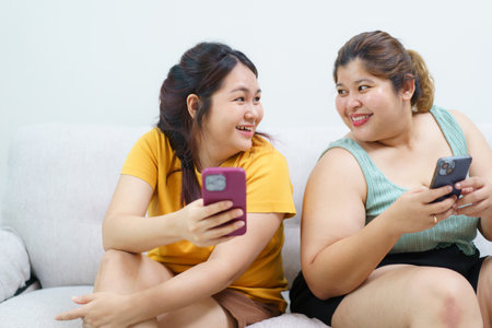 Happy Asian fat women friend excited in online shopping with special discount and using credit card to make a payment. Two Asian fat women staying together and buying goods in e-commerce website.の写真素材