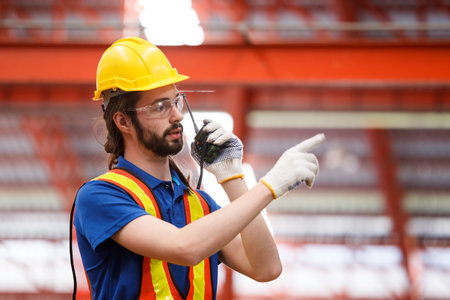 Smart and good looking senior factory or mechanical engineer standing in the factory portrait,...