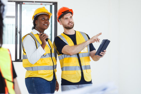 Engineer team discuss and examine about the building plan on blueprint together. Professional engineers working in the construction site.の写真素材
