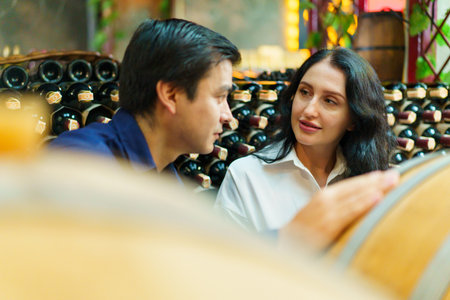 Portrait of wine testing expertises discussing together about wine in the wine cellar.