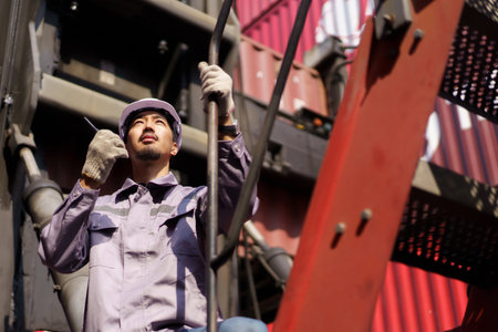 Asian male customs officer is currently conducting inspections of containers within the container...