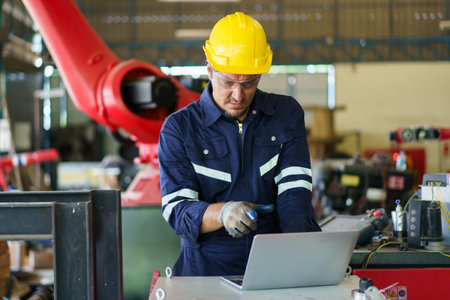Senior professional electrical or industrial engineer inspecting and repairing a robotic system in...