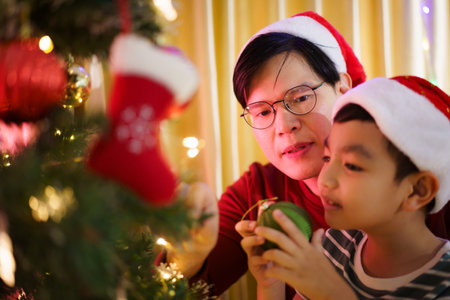 Happy cheerful Asian family celebrating Christmas and New Year dinner party together, a family with father and son. Asian lovely family celebrate Christmas - New Year festival.の写真素材