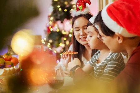 Happy cheerful Asian family celebrating Christmas and New Year dinner party together, a family with mother, father and son. Asian lovely family celebrate Christmas - New Year festival.の写真素材