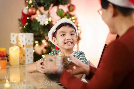 Happy cheerful Asian family celebrating Christmas and New Year dinner party together, a family with father and son. Asian lovely family celebrate Christmas - New Year festival.の写真素材