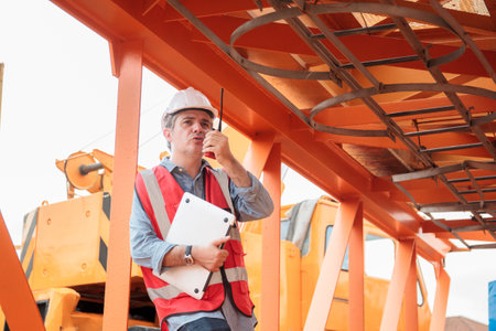 Senior caucasian white industrial engineer is performing inspection a heavy machines and computer...